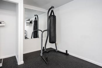 A black punching bag is hanging from a stand in a room